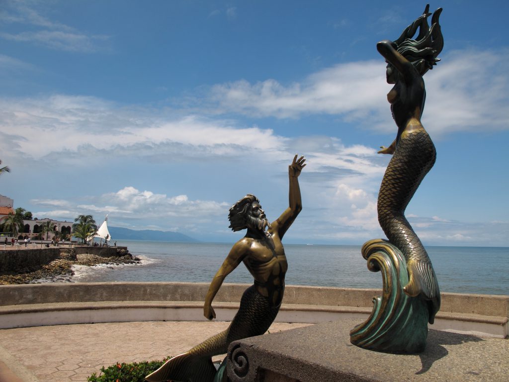 Mermaid statues on the Malecon walkway in Puerto Vallarta Mexico. Ocean in the background.