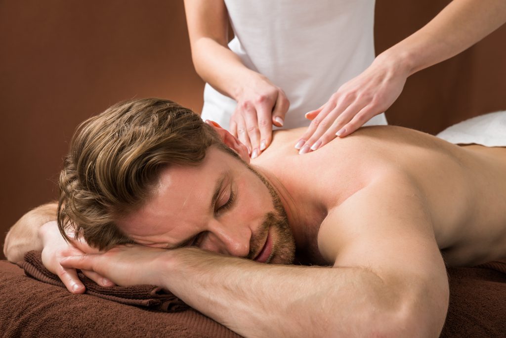 Portrait Of A Young Man Receiving Back Massage At A Beauty Spa